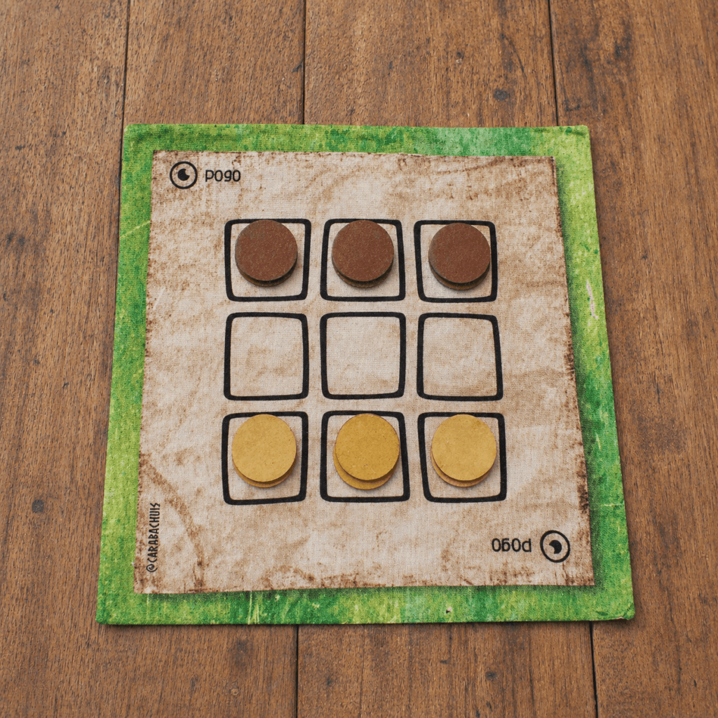 Tablero de Pogo extendido sobre una mesa de madera, las piezas están dispuestas en la posición inicial.