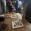 Juego abstracto Dao desplegado en un evento de juegos de mesa en Brasil, con jugadores observando la partida