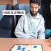 Alexis yendo en tren hacia Berlín, Alemania, frente al tablero portátil del Dao de Carabachuis con piezas de vidrio