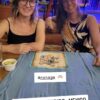 Juego de mesa Nonaga desplegado en bar, jugado por dos mujeres en un viaje