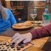 Jugador moviendo fichas negras del Keru de Carabachuis en un restaurante de Tolhuin, Tierra del Fuego