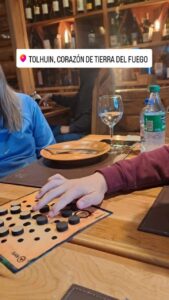 Jugador moviendo fichas negras del Keru de Carabachuis en un restaurante de Tolhuin, Tierra del Fuego