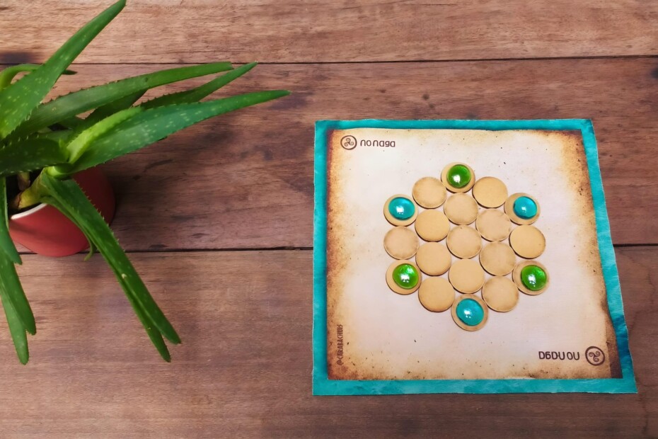 Tablero del juego Nonaga con fichas circulares y gemas de colores, listo para desafiar la estrategia en cualquier lugar.