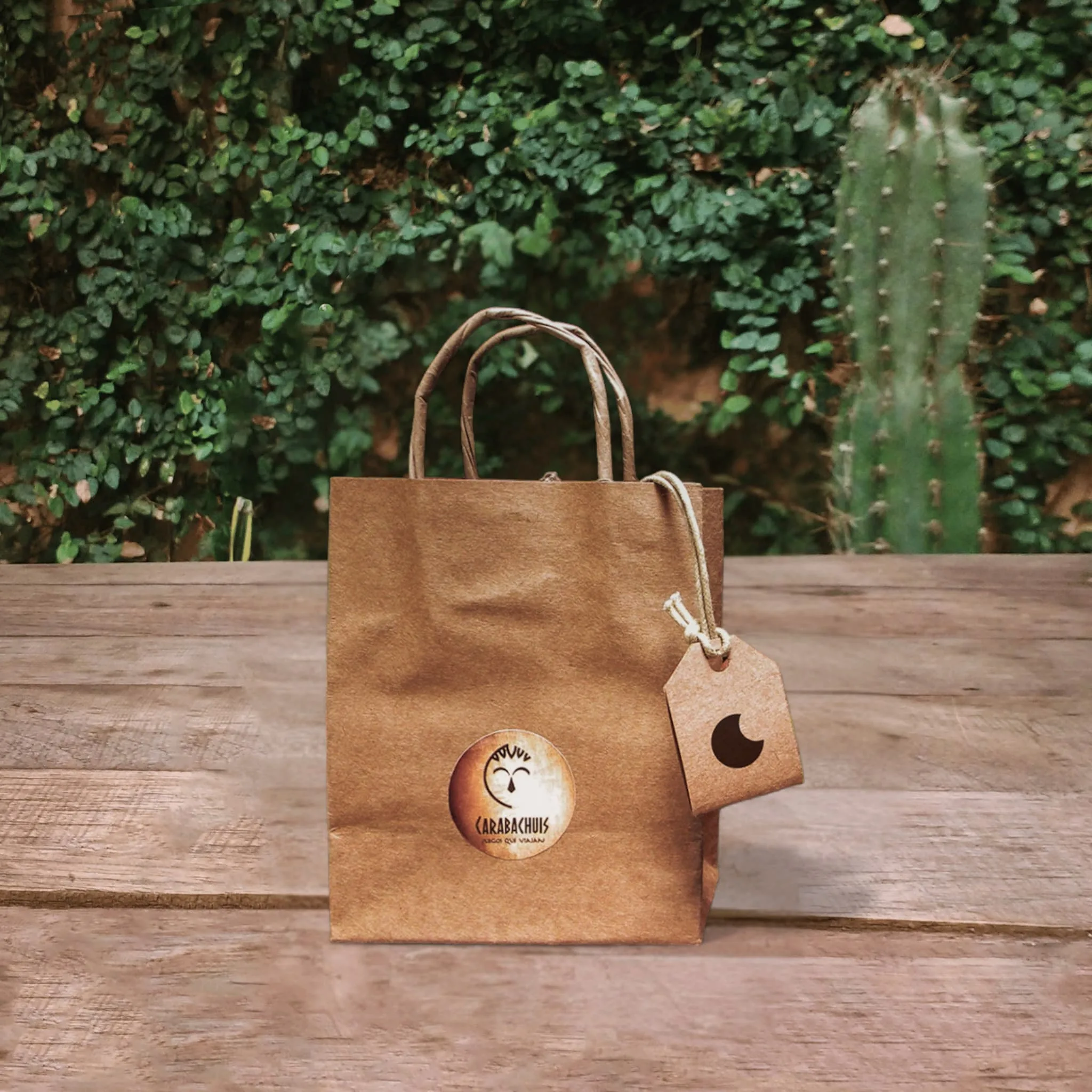 El Pogo en su packaging ya listo para entregarse, bolsa de papel madera con logo de Carabachuis sobre mesa de madera